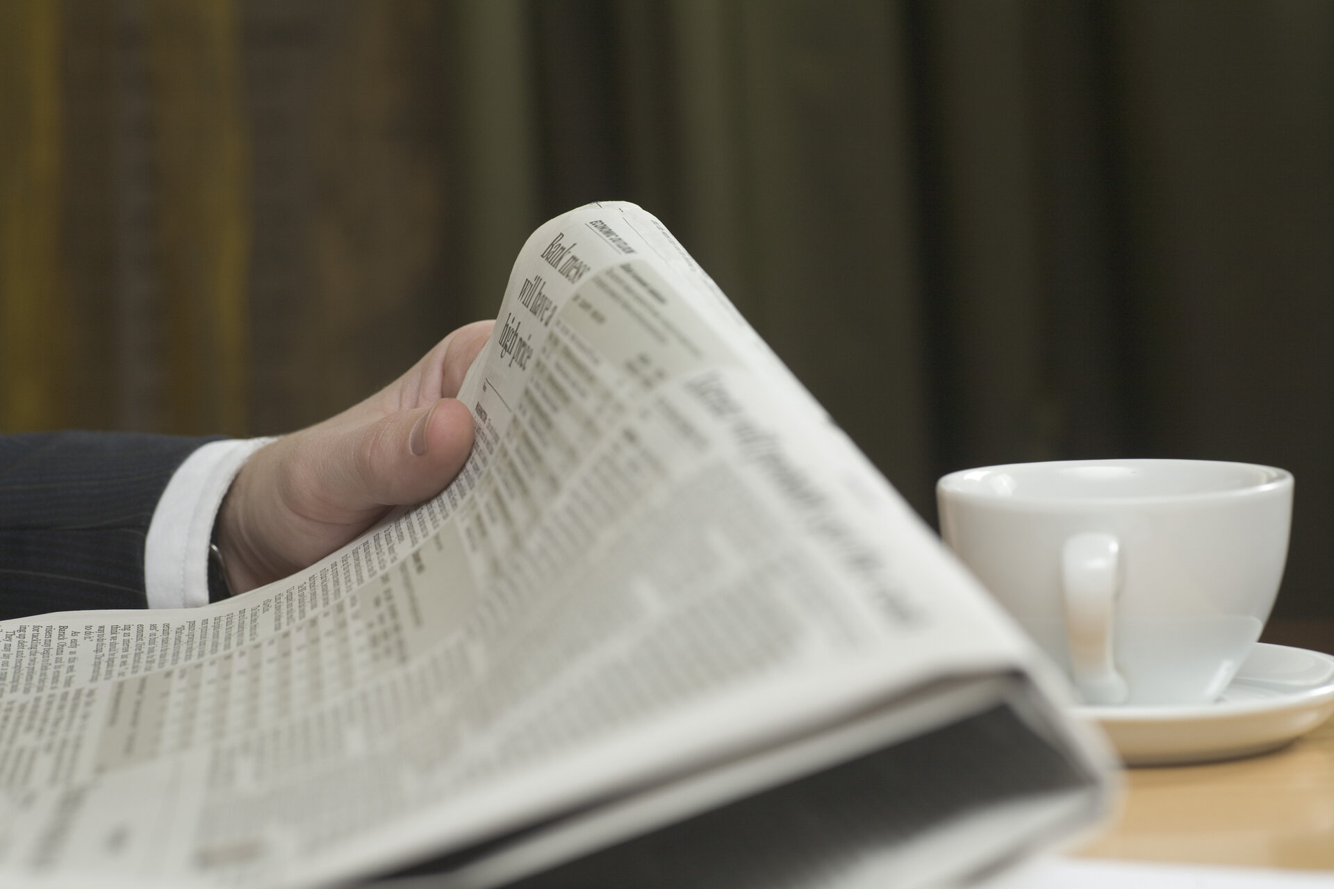 629-05599935© Masterfile Royalty-FreeModel Release: YesProperty Release: Yesdetail of businessman reading business paperClose up person reading a newspaper