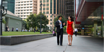 Business professional colleagues walking outside of the office and talking business.
